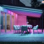 Colored lighting for a terrace with polycarbonate roofing and garden furniture featuring comfortable cushions