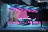 Colored lighting for a terrace with polycarbonate roofing and garden furniture featuring comfortable cushions