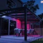 Glass terrace enclosure with sliding glass walls and colorful lighting for a clear night