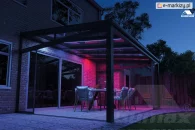 Glass terrace enclosure with sliding glass walls and colorful lighting for a clear night