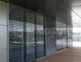 Facade blinds with open louvers mounted on the building wall