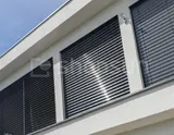 Recessed facade blinds covering the window opening