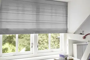 Transparent grey Roman blind on a classic wooden attic window